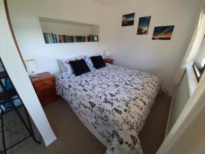 a bedroom with a bed with a black and white comforter at A Sea View B&B in Picton