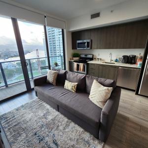 a living room with a couch and a kitchen at Ocean View Downtown Apt on 23rd Floor with Balcony, Rooftop Pool, Kitchen, Gym, & Restaurants in Miami