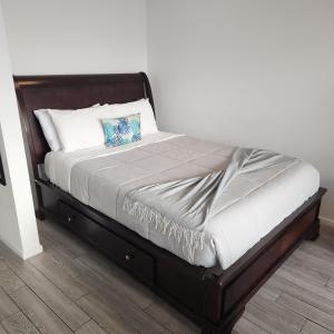 a bed with a wooden frame and white pillows at Ocean View Downtown Apt on 23rd Floor with Balcony, Rooftop Pool, Kitchen, Gym, & Restaurants in Miami