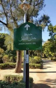 a green street sign on a light pole at dar Fès in Fez