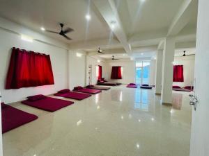 una sala de yoga con cortinas rojas y una fila de esterillas de yoga en Gaurav guest house, en Bodh Gaya