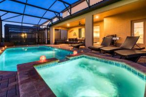 ein großer Pool mit Stühlen und ein Haus in der Unterkunft DreamCatcher House - Elite 7 Bed Luxury Escape in Kissimmee