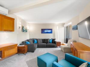 ein Wohnzimmer mit einem Sofa und einem Flachbild-TV in der Unterkunft Ski In/Out, Steam Shower, Pool, Hot Tub, Sauna in Whistler