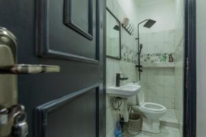 La salle de bains est pourvue de toilettes et d'un lavabo. dans l'établissement Oasis Villa Home Kampala, à Kampala