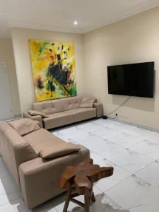 un soggiorno con divani e TV a schermo piatto di Luxury for you a Accra
