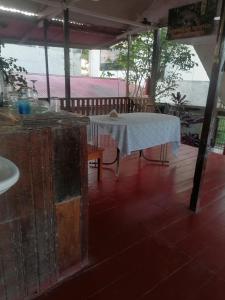 einen Tisch mit einem weißen Tischtuch auf einer Veranda in der Unterkunft Chimicuas House in Puerto Maldonado