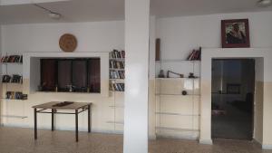 une chambre avec une table et une étagère avec des livres dans l'établissement Window on petra, à Wadi Musa