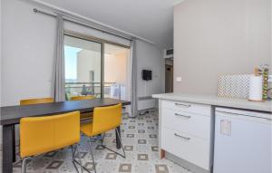 a kitchen with a table and yellow chairs at Nice Apartment In Mandelieu-La-Napoule in Mandelieu-la-Napoule