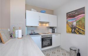 a kitchen with white cabinets and a stove top oven at Nice Apartment In Mandelieu-La-Napoule in Mandelieu-la-Napoule