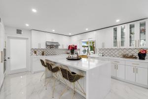 a kitchen with white cabinets and a large white island at MIA MANSION W/ POOL / BBQ /CABANNA / OUTDOOR BAR in Tamiami