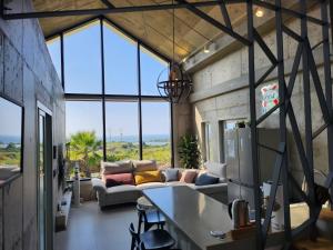 a living room with a couch and some windows at Dalthor Pension in Jeju