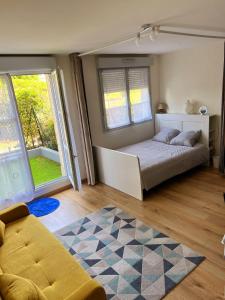 a bedroom with a bed and two windows and a rug at Appartement Disneyland Paris Val d'Europe La vallée Village parking 500m gare Val d'Europe in Montévrain