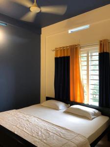 a bedroom with a bed and a window with curtains at Royal residency in Tindummal