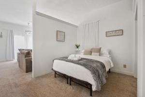 een witte slaapkamer met een bed en een bank bij Detached guesthouse in Belmont Heights in Long Beach