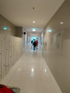 un corridoio in un edificio con gente che cammina lungo il corridoio di Apartemen Pakuwon Educity yale a Surabaya