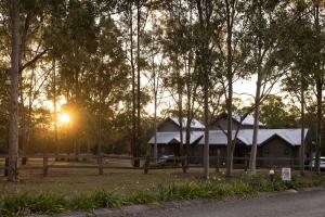 a house in the middle of a field with trees at Hermitage Lodge in Pokolbin