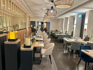 a long row of tables and chairs in a restaurant at Hotel Schöne Aussicht, Stilvoll modern, direkt am Rüstersieler Hafen in Wilhelmshaven