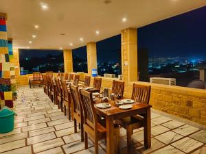 a dining room with a long table and chairs at Hotel Royal Heritage in Jaisalmer