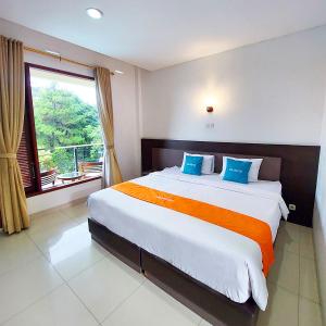Un dormitorio con una cama grande y una ventana en Sangga Buana Resort & Convention Hotel en Pacet