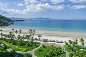 een luchtzicht op een strand met palmbomen en hutten bij TONY ESTATES Danang Beach Luxury Apartments in Da Nang