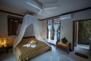 Schlafzimmer mit einem Bett mit Moskitonetz in der Unterkunft Puri Bayu in Ubud