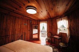 um quarto com uma cama num quarto de madeira em Pipas Terroir - Vale dos Vinhedos - Pousada Temática em Bento Gonçalves