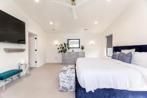 a white bedroom with a large bed and a tv at BRAND NEW Modern 5 Bd, 3 Story Home in Sugarhouse! in Salt Lake City