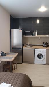 uma cozinha com um frigorífico e uma máquina de lavar roupa em Гостьовий Будинок Апартаменти в тихому центральному районі Полтави Смарт-квартири em Poltava