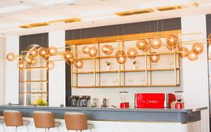 a kitchen with a bar with brown chairs at Uma Hotel and Residences in Naga