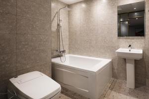 uma casa de banho com uma banheira, um WC e um lavatório. em Mariposa Hotel Songtan em Pyeongtaek