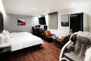a hotel room with a bed and a desk at Mariposa Hotel Songtan in Pyeongtaek