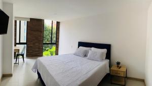 a bedroom with a bed and a table and a window at Apartamento Lauret en Laureles in Medellín +19 photos