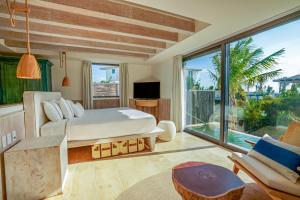 a bedroom with a bed and a large window at Naay Boutique Hotel Holbox in Holbox Island