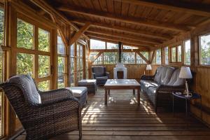 un porche cubierto con sillas de mimbre y mesa en Casa Johann, your charming holiday home in Cund, en Cund