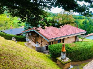 een huis met een rood dak op een heuvel bij Chalet Le Vintage in La Bresse