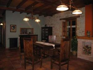 a dining room with a table and chairs and a fireplace at Hotel Casona De Tresali in Argüero