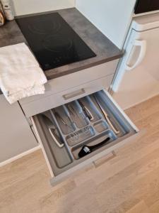 an open drawer of an oven in a kitchen at Cozy apartment with a yard in Kivistö near Airport in Vantaa