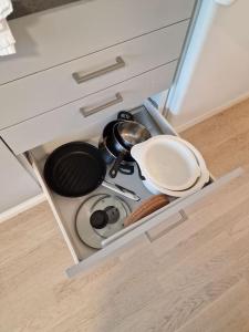 a kitchen drawer with a stove and pans in it at Cozy apartment with a yard in Kivistö near Airport in Vantaa