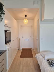 een kamer met een hal met een deur en een televisie bij Cozy apartment with a yard in Kivistö near Airport in Vantaa