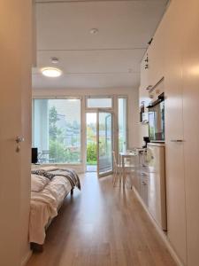 1 dormitorio con 1 cama y cocina con mesa en Cozy apartment with a yard in Kivistö near Airport, en Vantaa