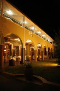 un gran edificio con arcos y luces por la noche en Kimberley Club Guesthouse en Kimberley