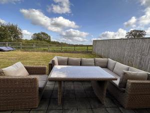 un sofá y una mesa de centro en el patio en Hot Tub & GF Bedroom in Countryside Holiday Home, en Chippenham