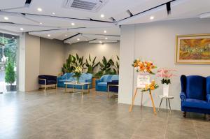 a waiting room with blue chairs and flowers at Arcadia Hotel Manado in Manado