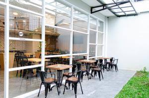 un grupo de mesas y sillas en un restaurante en Arcadia Hotel Manado, en Manado