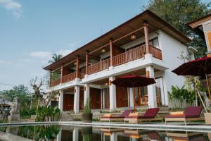 uma villa com uma piscina e mobiliário de pátio em Sanubari Ubud em Ubud