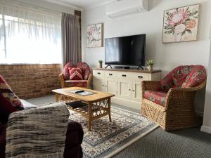 a living room with two chairs and a flat screen tv at Highgrove in Promised Land