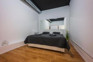 1 dormitorio con 1 cama en una habitación blanca en Wellness Apartman Vrakuna en Bratislava