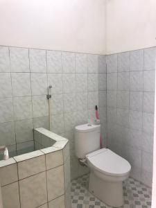 een witte badkamer met een toilet en een bad bij VILLA BUDI HUTAMA in Jetis