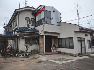 una casa blanca con muchas ventanas en Kounotori no Sato no Yado - Vacation STAY 12510, en Kōnosu