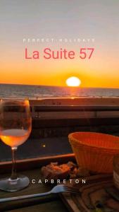 ein Glas Wein auf einem Tisch mit Sonnenuntergang in der Unterkunft La Suite 57 in Capbreton